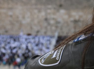a woman with long hair standing in front of a crowd of people