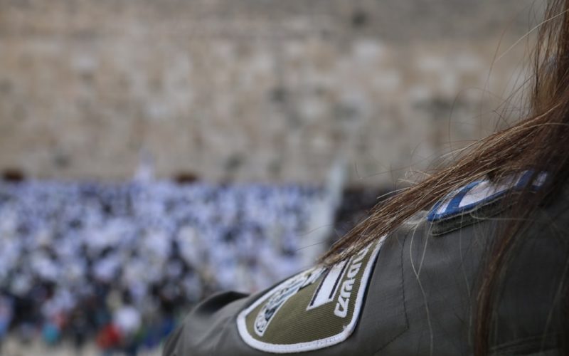 a woman with long hair standing in front of a crowd of people