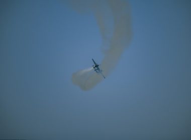 A plane flying in the sky with smoke coming out of it