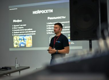 A man standing in front of a projector screen